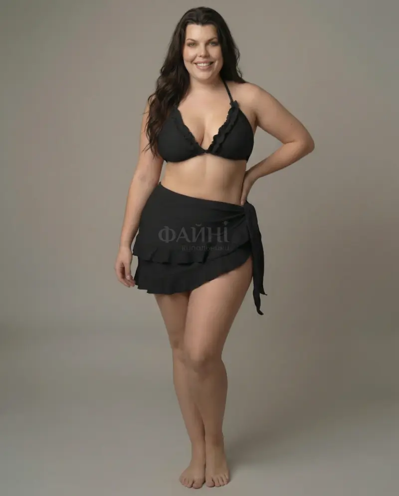 Жінка в чорному купальнику та парео посміхається