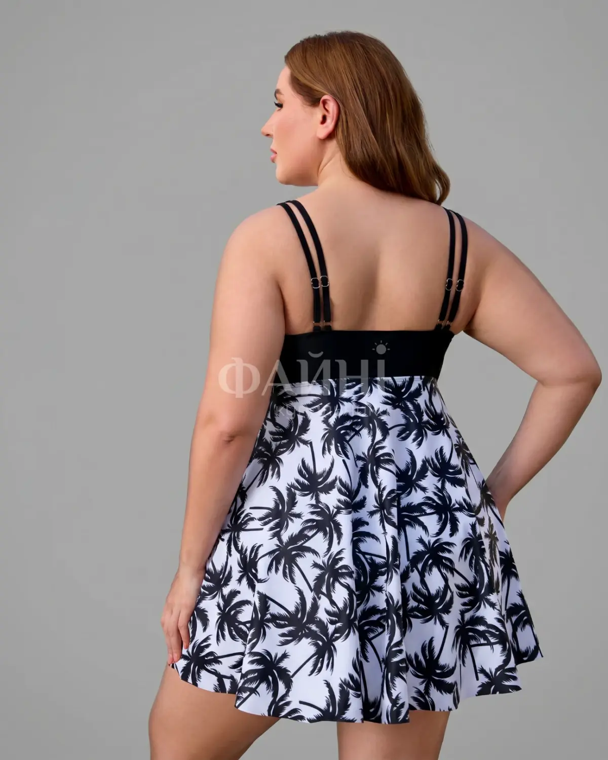 Woman in white palm print dress, back view
